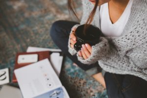 A girl reading a book with coffee in her hands.