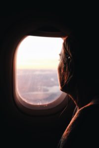 A girl looking out of an airplane window.