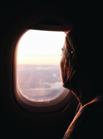A girl looking out of an airplane window.