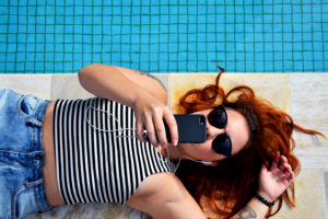 girl on her cell phone by the pool