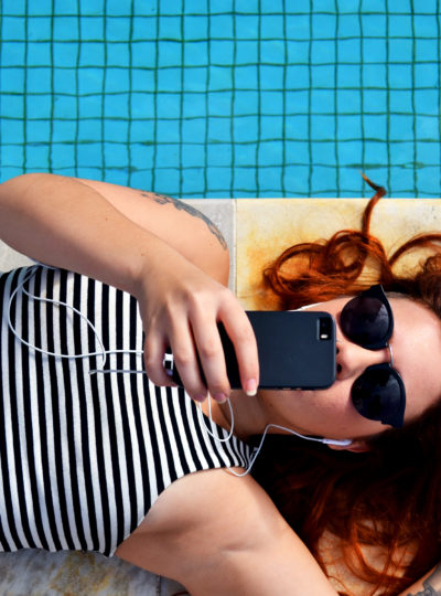 girl on her cell phone by the pool