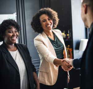 A female professional greets a colleague.