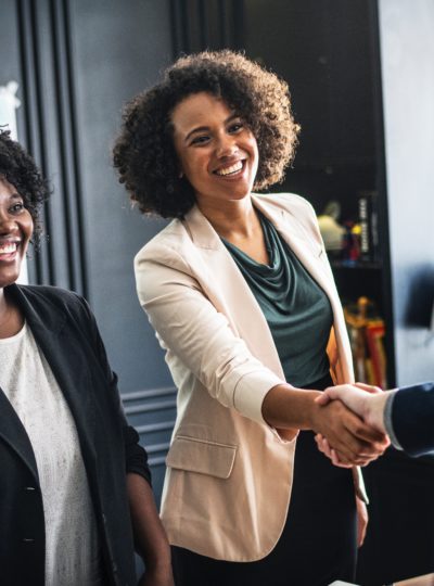 A female professional greets a colleague.