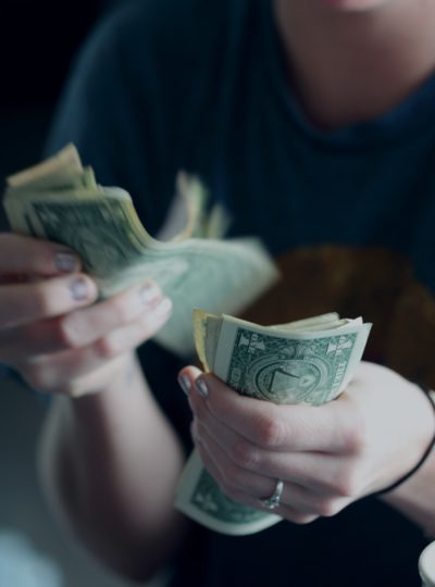 Stock photo of a woman counting dollar bills.